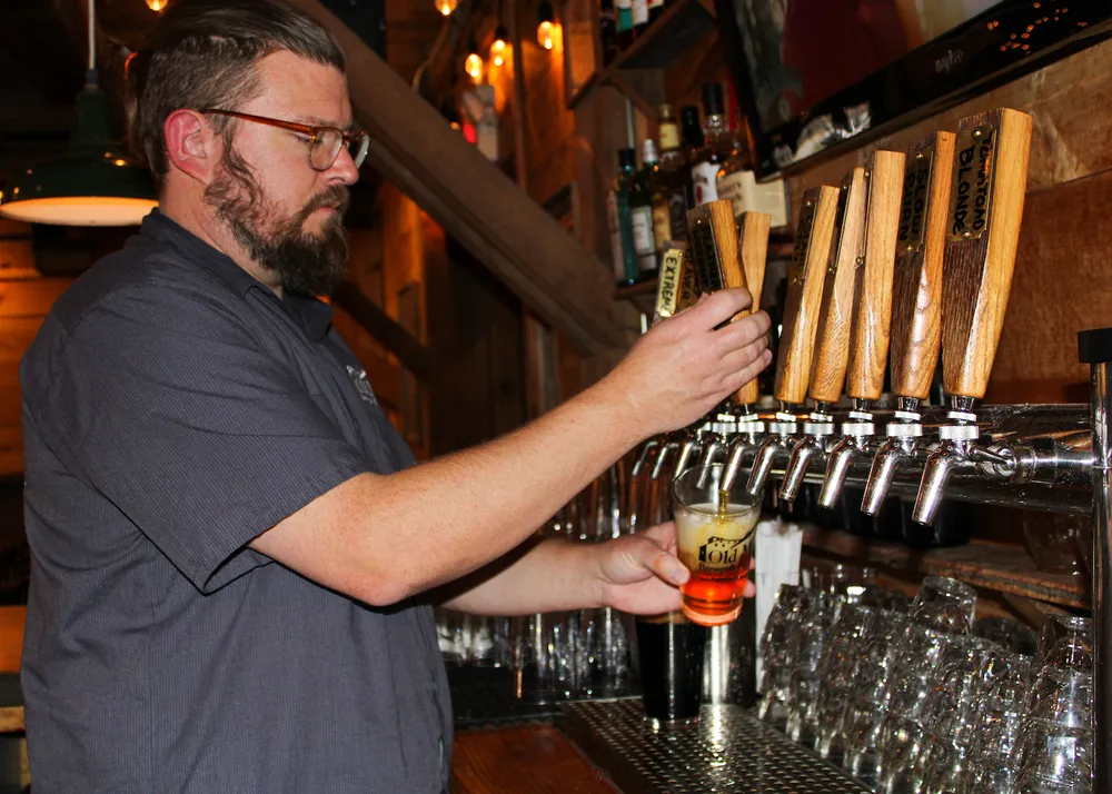 Bartender pouring a craft beer at the Old Mill tap